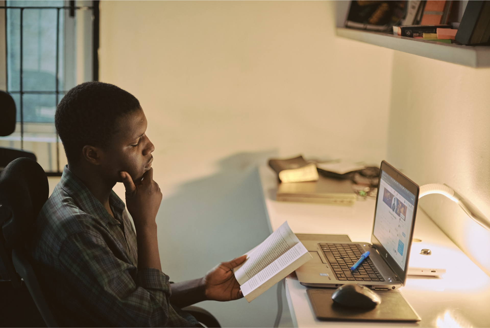 A student smiling in front of a laptop